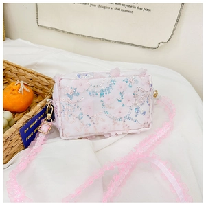 Detailed shot of white sequin floral embroidery and pink lace strap on kids shoulder bag