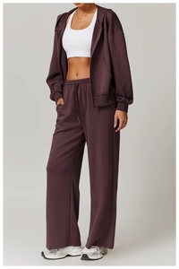 Detailansicht des dunkelvioletten Lounge-Sets mit Kapuzenjacke und weitem Beinverlauf