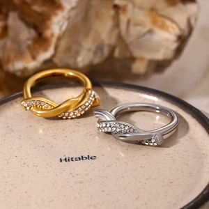 Macro shot of twisted knot rings set with white zircon stones in gold and silver