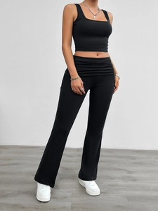 Women's black two-piece set featuring square neck crop top and flared pants on model