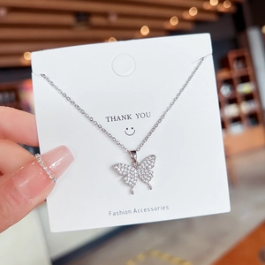 Elegant silver butterfly necklace with sparkling crystals on a white display card