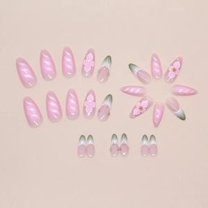 Detailed view of floral press-on nails with pink stripes and delicate gold bead accents