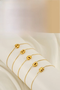 Detailed close-up of golden bubble letter charms A to F on a delicate link chain bracelet