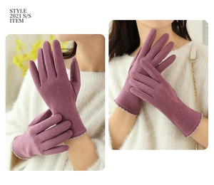 Detail of purple winter gloves showing fine plush texture and white stitched cuffs