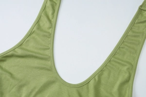 Detail of the grass green knit dress showing the deep U-neckline and fine stitching
