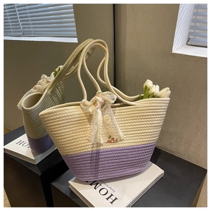 Detail of two-tone woven tote bag with floral scarf and tight textured straw pattern