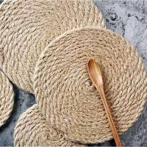 Detail view of woven jute coasters in three sizes with a decorative wooden spoon