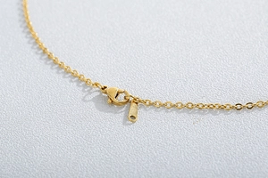 Macro shot of the durable lobster clasp and metallic links on the gold-plated necklace