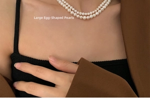 Close-up of large egg-shaped freshwater pearls on a layered 14K gold necklace