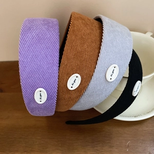 Détail de quatre serre-têtes en velours côtelé avec boucle décorative et lettrage Ai you