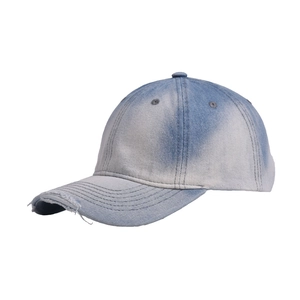 Close-up of distressed denim baseball cap featuring frayed holes and washed blue texture