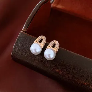 Elegant 18K gold plated pearl earrings with diamond accents on leather jewelry box