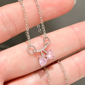 Primer plano del collar planeta corazón rosa con piedras brillantes en cadena de plata