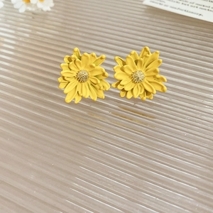 Macro view of 3D yellow daisy stud earrings with detailed petals and golden pistils