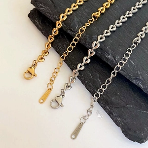 Detail of 18k gold and silver heart-shaped woven chain bracelets with lobster clasps