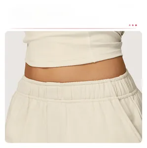 Détail de la taille haute élastique sur ce jogging large beige pour un confort réglable