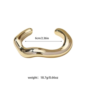 Detailed view of golden irregular wave metal bracelet with 6cm diameter and 18.7g weight