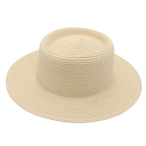 Detailed close-up of woven paper straw texture on a classic beige boater sun hat