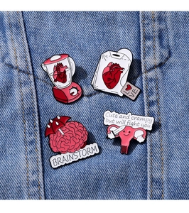 Detailansicht kreativer Emaille-Anstecknadeln für Organe auf blauem Denim-Hintergrund