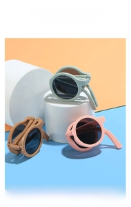 Detailed view of foldable round children sunglasses in mint green, pink, and caramel brown