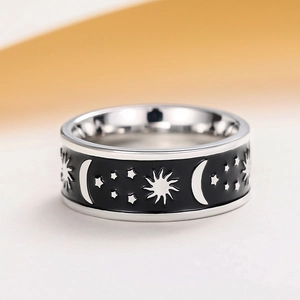 Detailed macro view of celestial star and moon patterns on a wide enamel unisex band