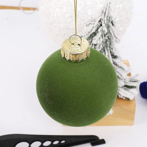 Detailed close-up of a 6cm green flocked PET Christmas ball ornament with a gold hanging string