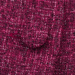 Elegant purple tweed jacket detail with textured weave and matching fabric button