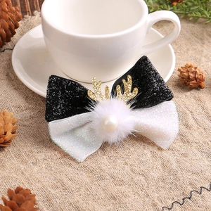 Christmas reindeer antler hair clip with white fur ball and festive bow on linen surface