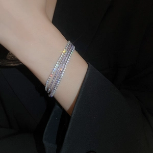 Dettaglio di bracciali elastici multistrato con perle sintetiche e cristalli al polso