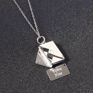 Macro view of silver stainless steel envelope necklace with hidden Love You engraving