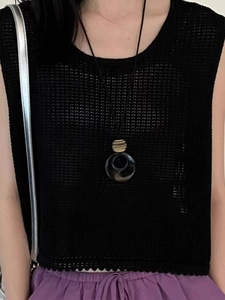 Detail of long necklace featuring a faux agate ring pendant on a black cord