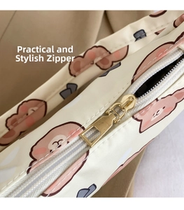 Detailed close-up of a white fabric shoulder bag showing pink bear print and golden zipper