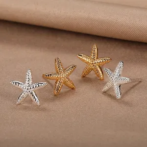 Detailed view of starfish stud earrings in gold and silver with textured finish