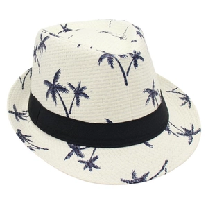 Detail of white woven sun hat with navy palm tree patterns and black grosgrain ribbon band