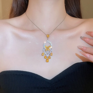 Close-up of butterfly pendant necklace with yellow drop stones on elegant female model