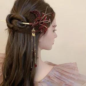 Traditional red Lycoris flower hair pin with golden tassels on a bun hairstyle