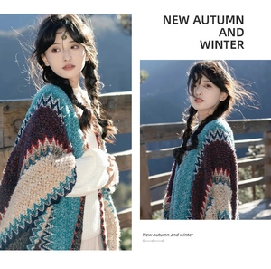 Detail of colorful wave knit shawl with ethnic pattern and tassel hem on outdoor model