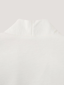 Close-up of white sleeveless vest with premium vertical textured knit fabric detail
