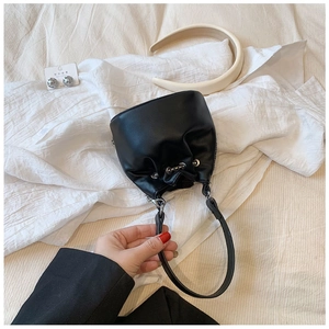 Detailed view of the black mini bucket bag with drawstring closure and chain strap handle