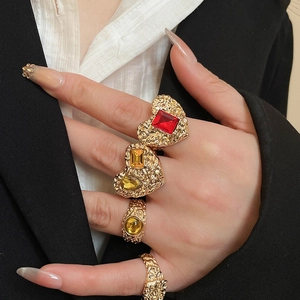 Detailed macro view of vintage gold textured heart rings with red and yellow gemstones