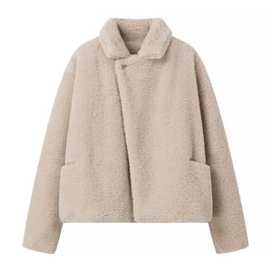 Dettaglio giacca corta in pile beige con colletto a rever e tasche frontali su fondo bianco
