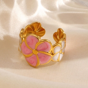 Adjustable golden flower ring with pink and white enamel petals on silk background