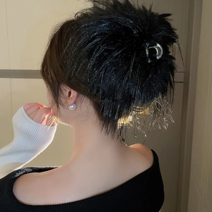 Detailed view of plush black feather hair claw clip on model's hair for a fuzzy look