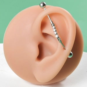 Detail of stainless steel industrial barbell with six white zircons on ear model