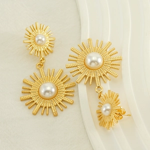 Vintage gold plated sunburst drop earrings with pearls on white display stand