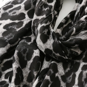 Close-up detail of soft leopard print scarf fabric with black and grey pattern texture