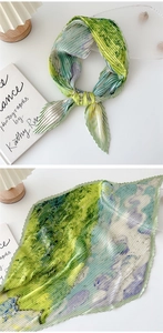 Detailed view of artistic pleated silk scarf with green and blue gradient ink pattern