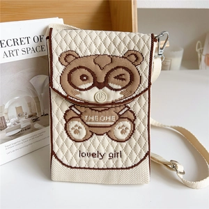 Detail of knitted mini crossbody bag with cartoon bear and beige textured diamond pattern