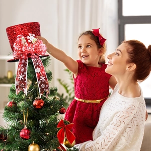Red sequin Christmas tree topper hat with snowflake ribbon on a decorated tree