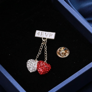 Detail of red and white heart pin with 4EVR banner in blue velvet jewelry box